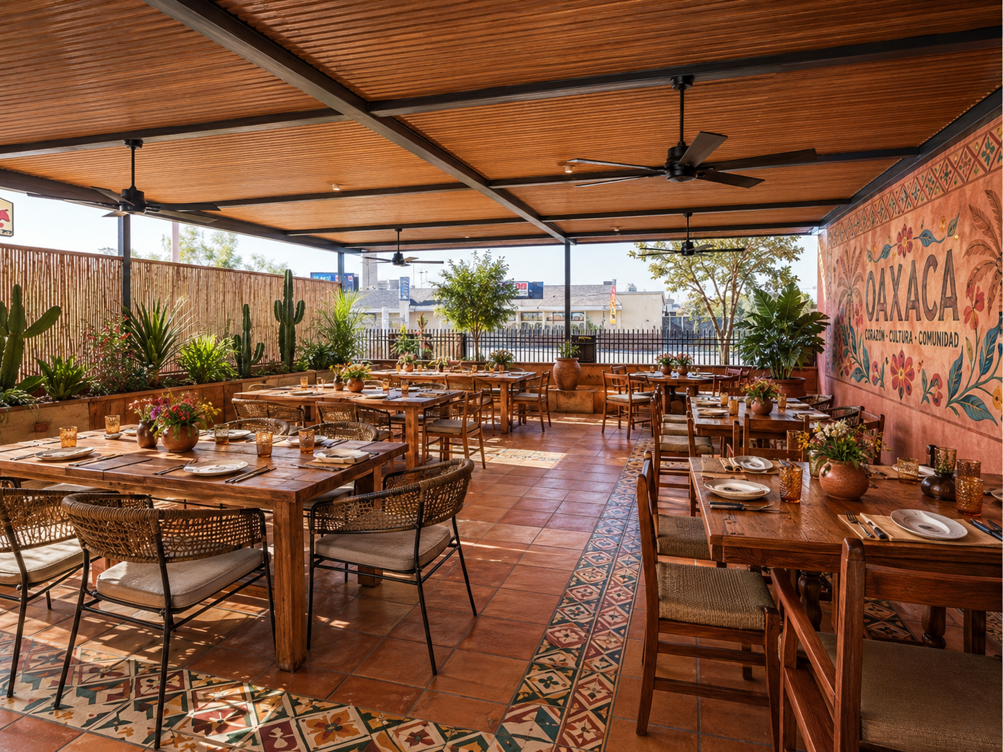 The patio at Oaxaca Restaurant in Fresno, set with wooden tables under a painted mural