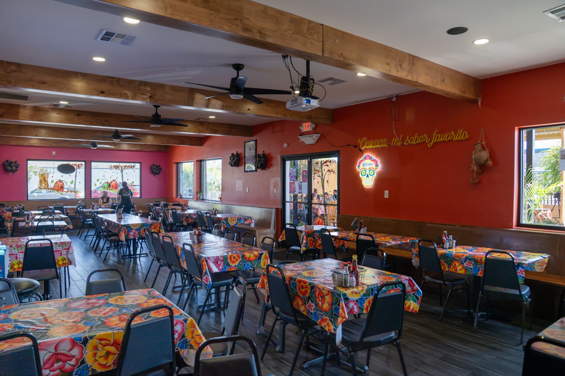 The dining room with colorful floral tablecloths and warm red walls